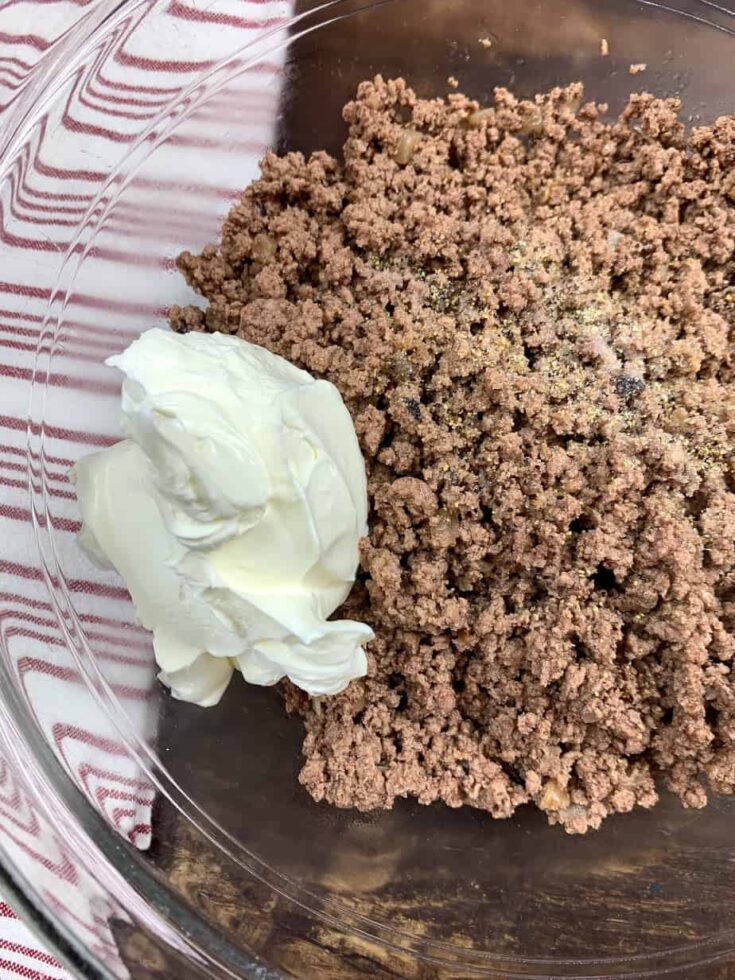 Ground beef in a large glass bowl with sour cream