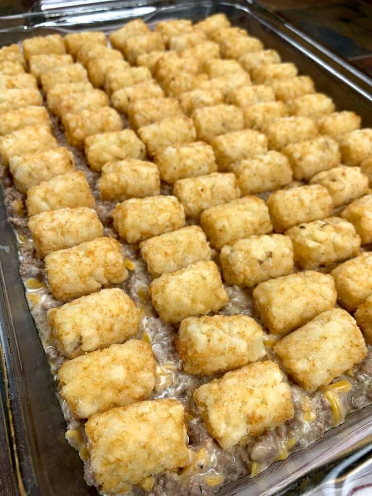 Tater tots on top of ground beef in a casserole dish