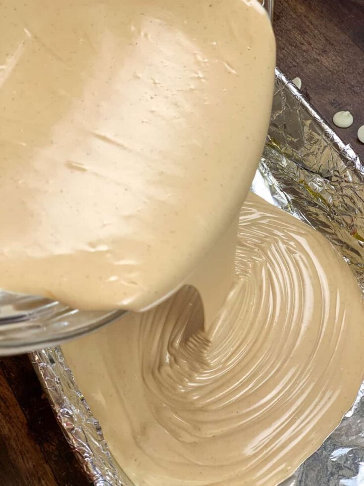 Peanut butter fudge bring poured into a casserole dish.