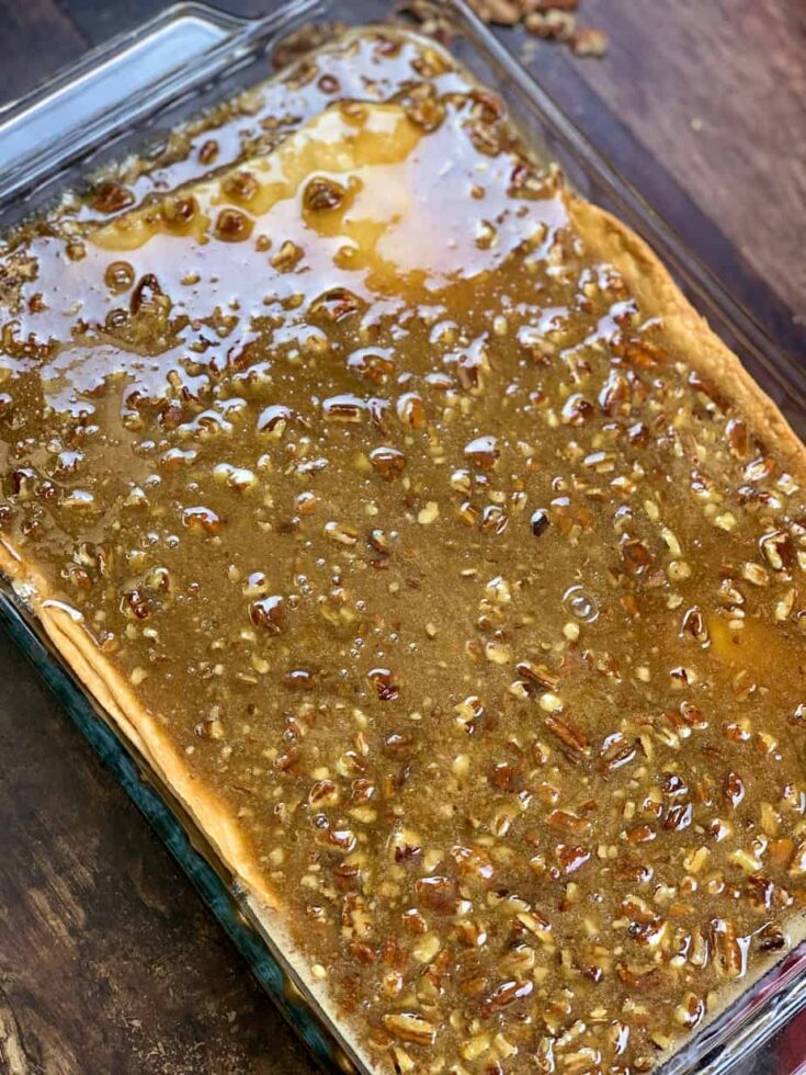 Pecan pie cobbler mixture over a cooked crust in a casserole dish