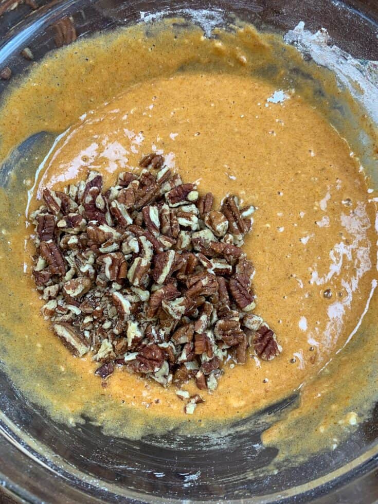 Pumpkin roll ingredients and pecans in a glass bowl