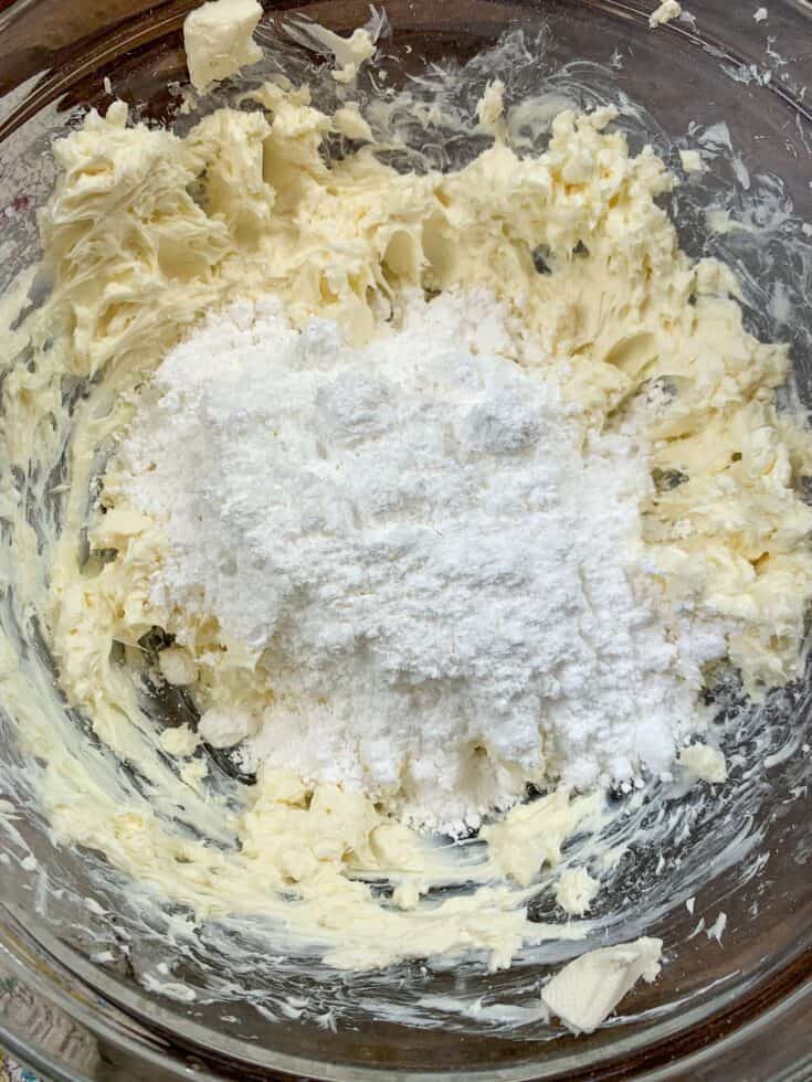 Cream cheese and powdered sugar in a glass bowl