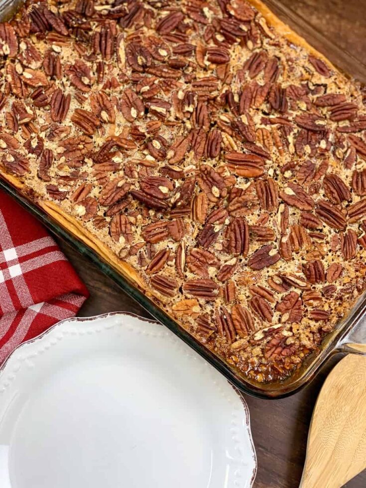 Pecan pie cobbler in a casserole dish and a white plate