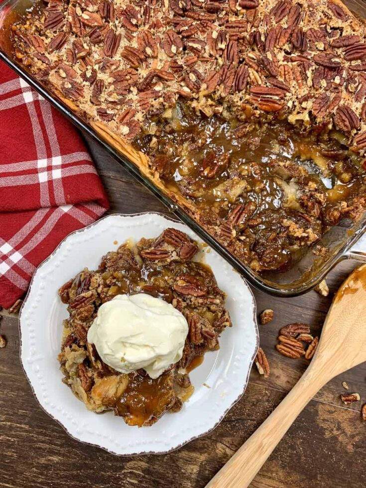 Pecan pie cobbler with ice cream on a plate and in a casserole dish.