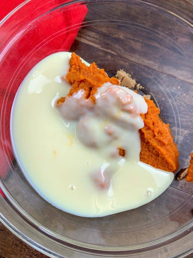 Sweetened condensed milk, pumpkin puree, and brown sugar in a glass bowl