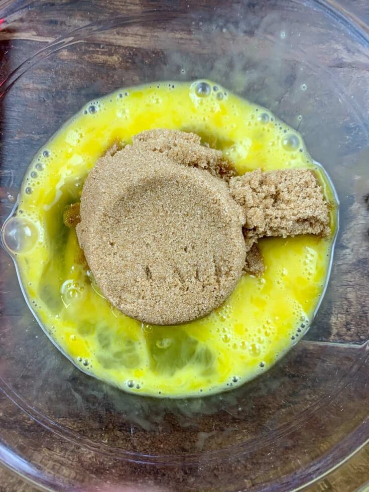 Brown sugar and eggs in a glass bowl