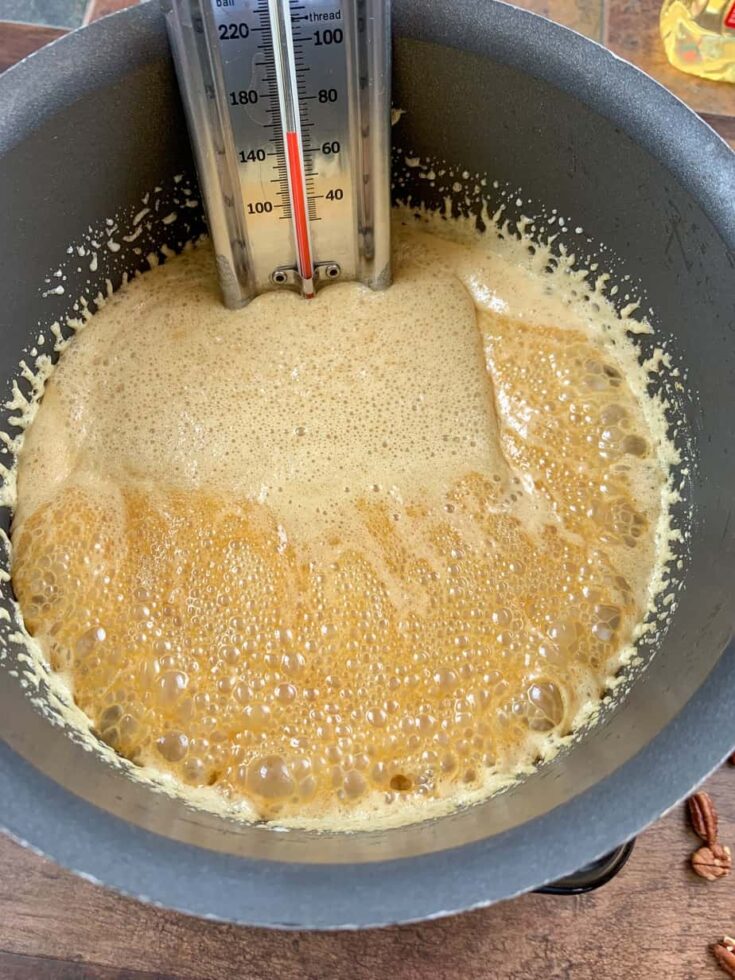 Boiling sugar with a thermometer in a saucepan.