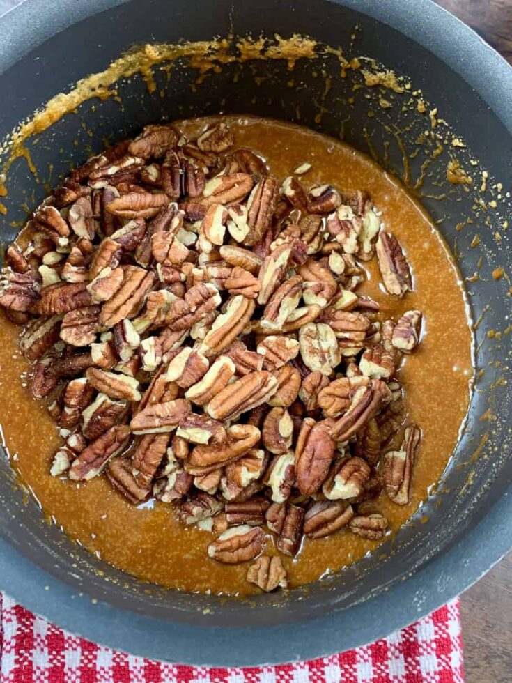 Pecans in a saucepan with melted sugar