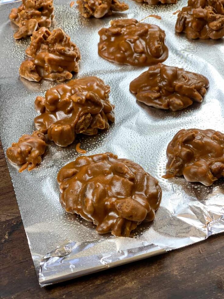 Praline pecans lined up on tinfoil