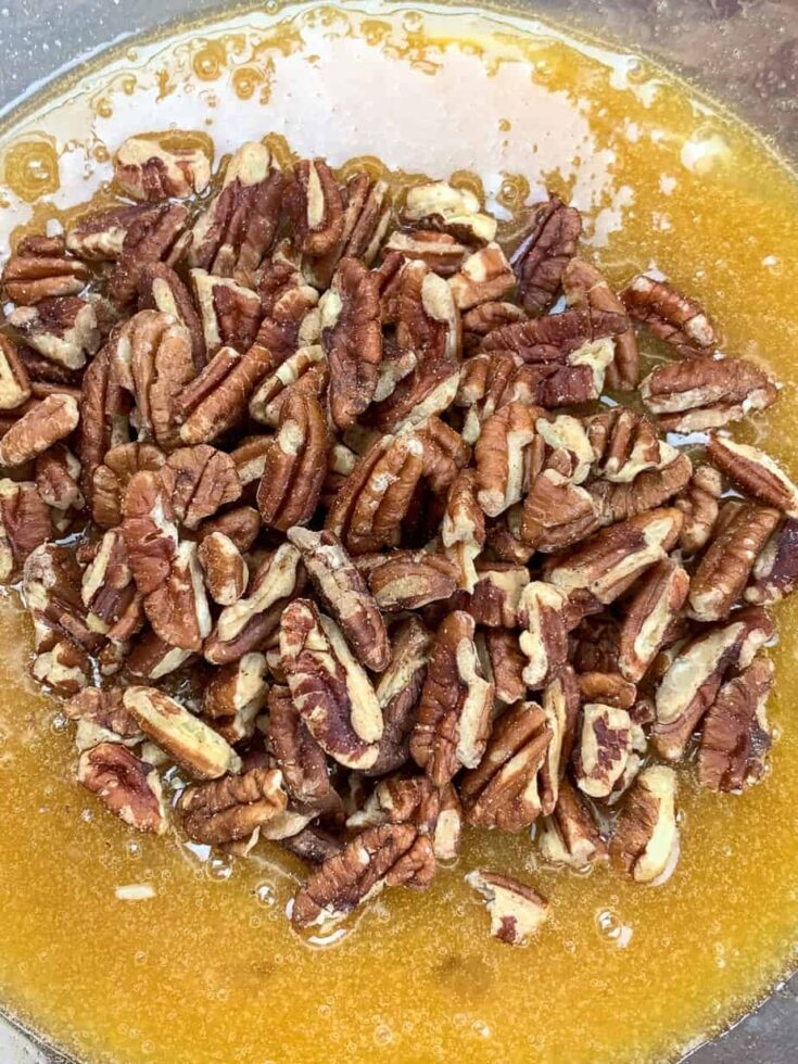 Pecans in a bowl with pecan pie filling 