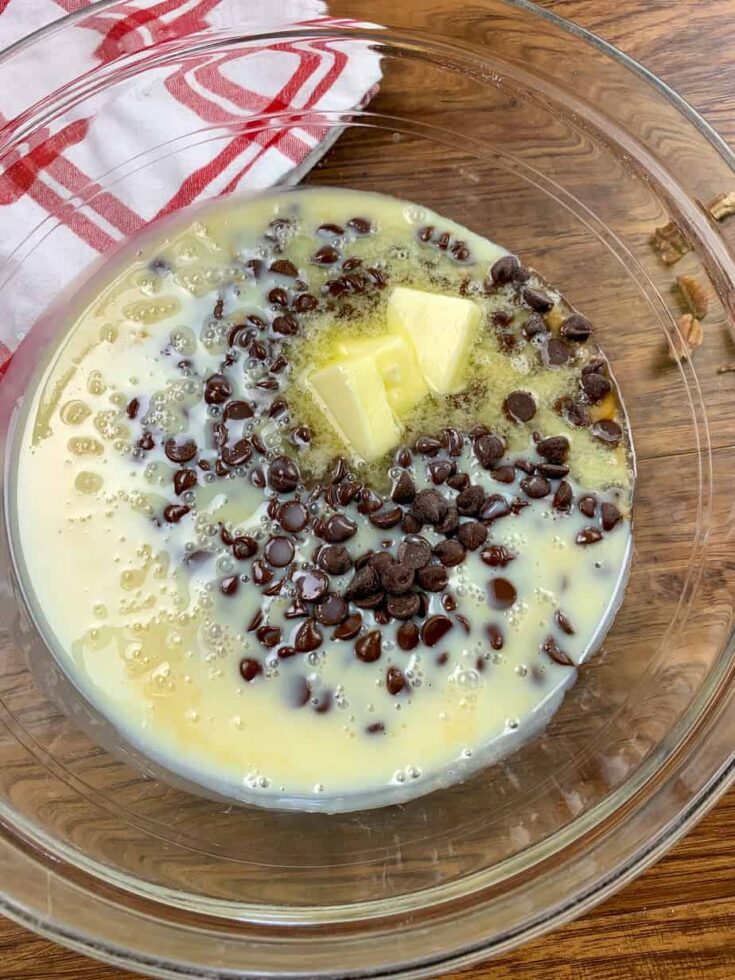 Melted chocolate chips, butter, and sweetened condensed milk in a glass bowl