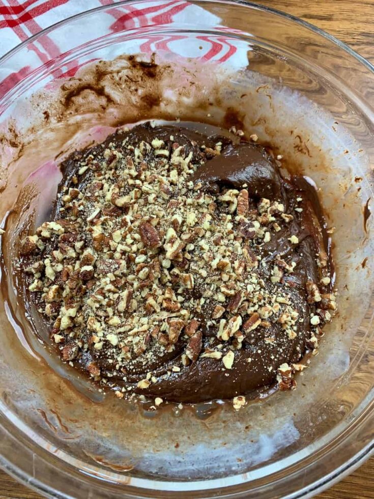 Melted chocolate and pecans in a glass bowl