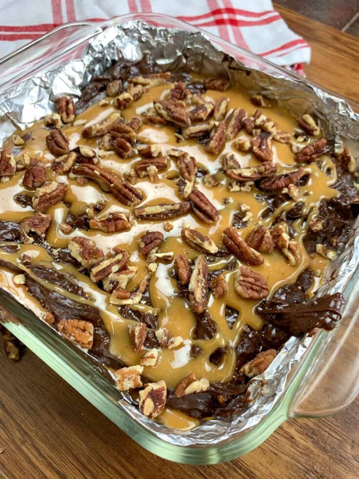 Chocolate turtle fudge with pecans in a casserole dish.