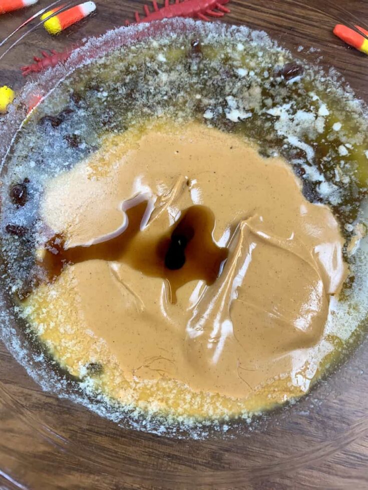 Melted peanut butter and chocolate, with vanilla extract, in a glass bowl