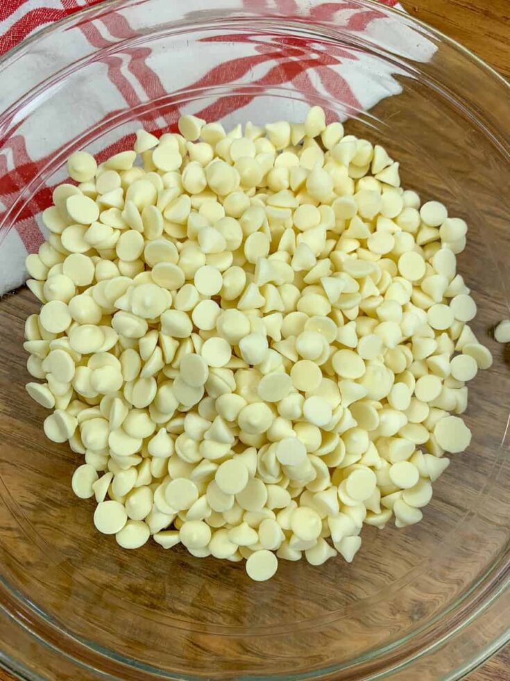 White chocolate chips in a glass bowl for peppermint fudge