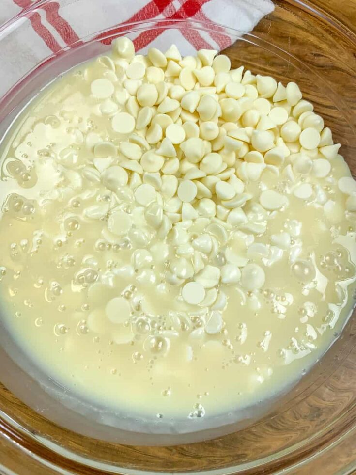 White chocolate chips and sweetened condensed milk in a medium glass bowl