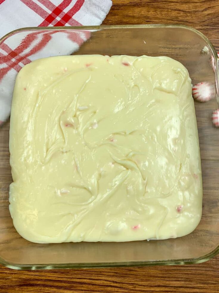 White chocolate fudge with peppermint in a small glass container.