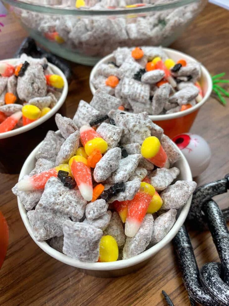 Muddy buddies with candy corn and Halloween candy in a paper dish