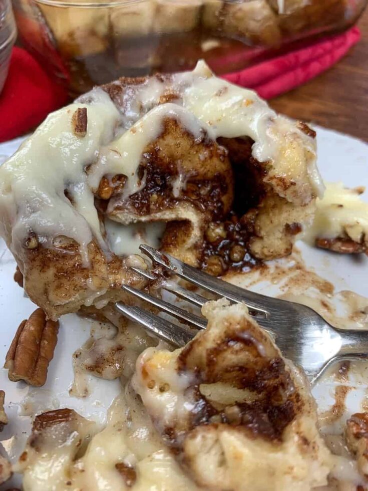 A cinnamon roll on a plate with a fork