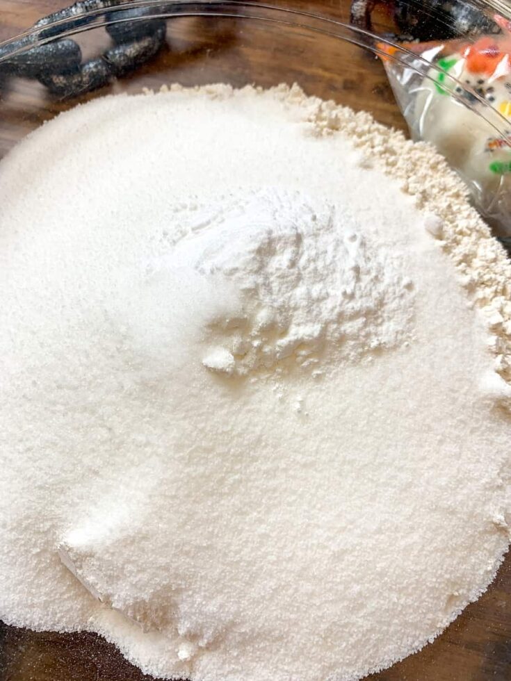 Flour, sugar, baking soda, and baking powder in a glass bowl