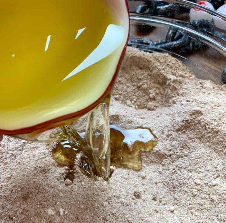 Oil being poured into Halloween cake ingredients.