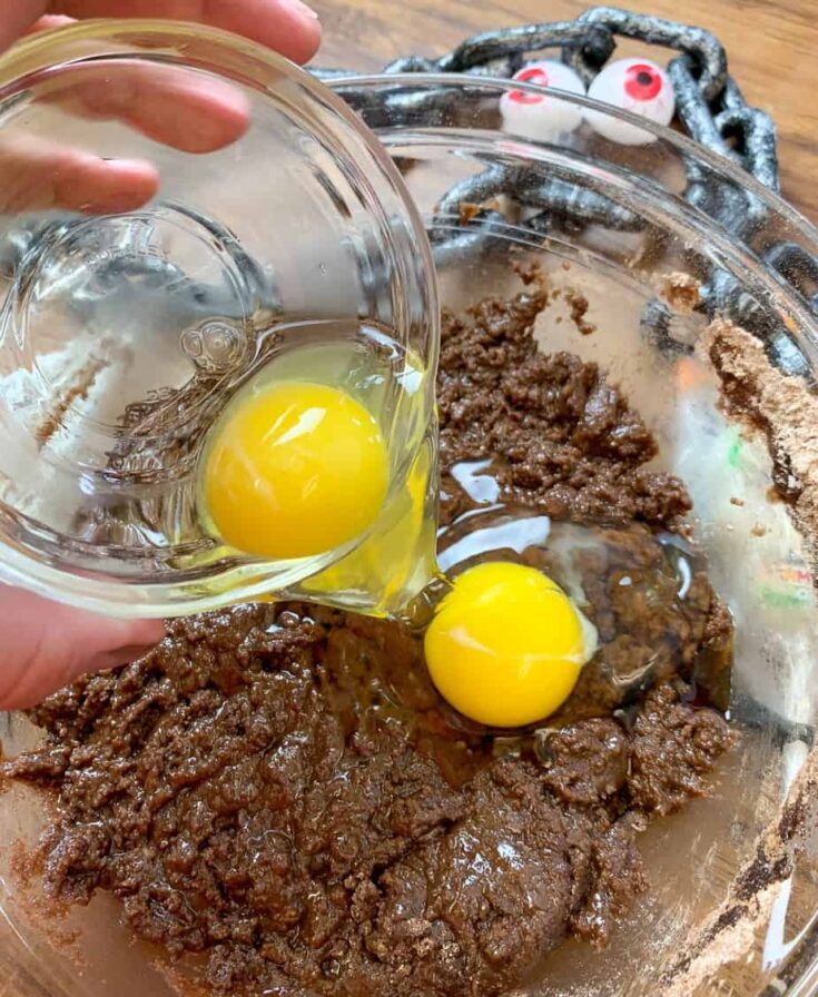 Eggs being poured into Halloween cake batter