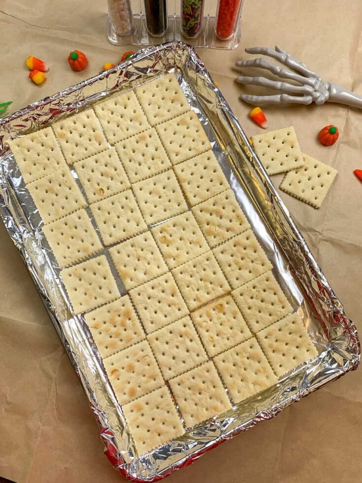 Saltine crackers laid out on a cookie sheet for crack candy