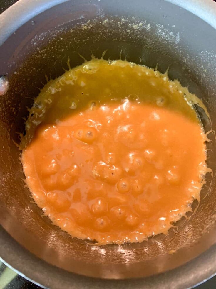 Boiling brown sugar and butter in a saucepan to create toffee