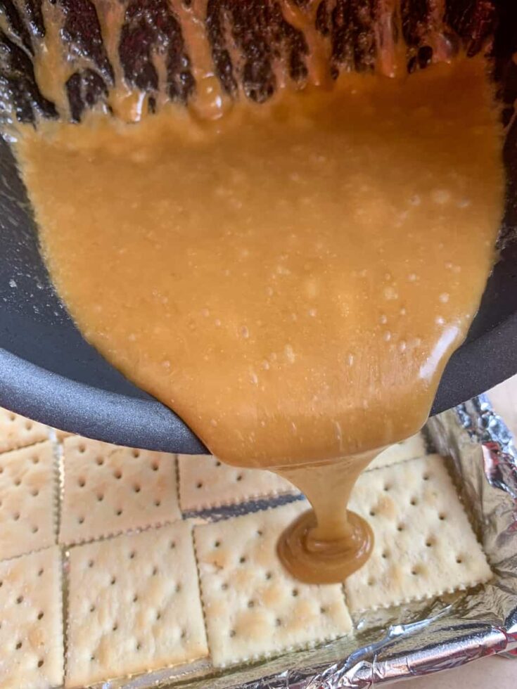 Pouring toffee over saltine crackers