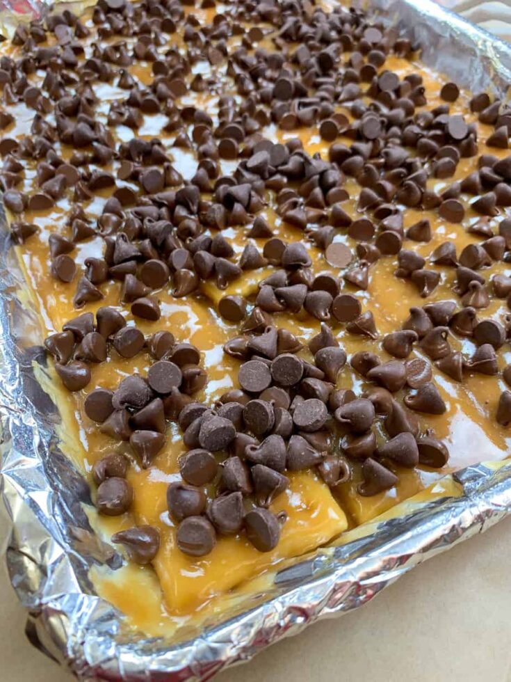 Chocolate chips on top of toffee and crackers