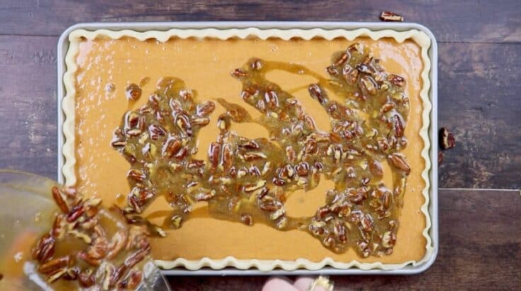 Pouring pecan pie filling into pumpkin pie.