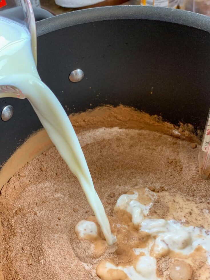 Pouring milk into a saucepan.