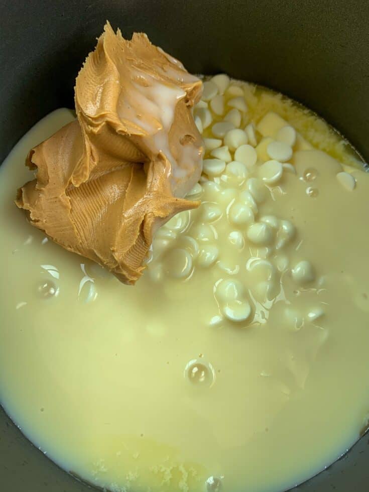 Peanut butter, sweetened condensed milk, white chocolate chips, and butter melting in a saucepan.