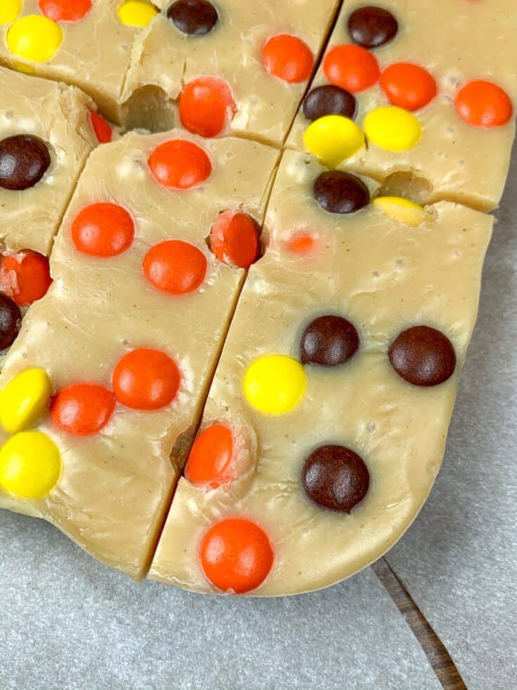 Peanut butter fudge with Reese's Pieces cut up in sections.