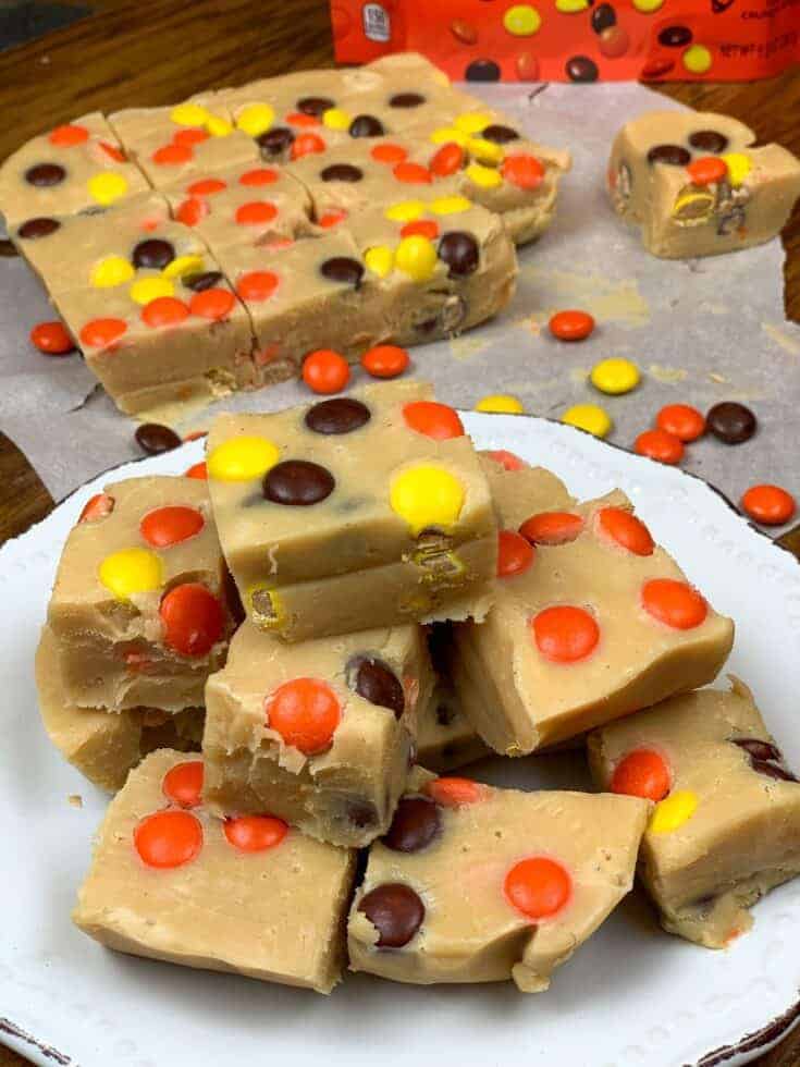 Peanut butter fudge cut up and stacked on a white plate