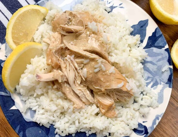 Chicken and rice on a plate with lemon wedges