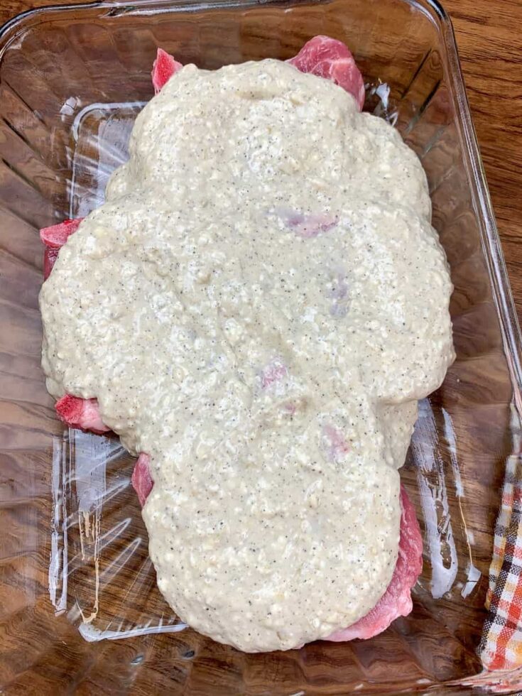 Pork chops with gravy smothered over the top of them. 