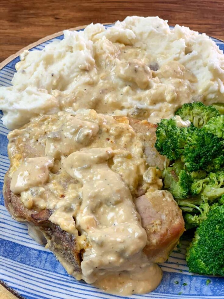 Pork chops on a plate with mashed potatoes and broccoli