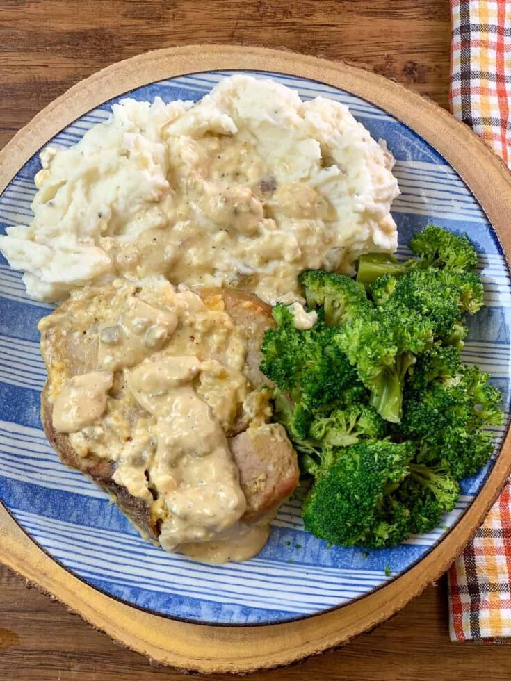 A blue plate of pork chops, mashed potatoes, and broccoli