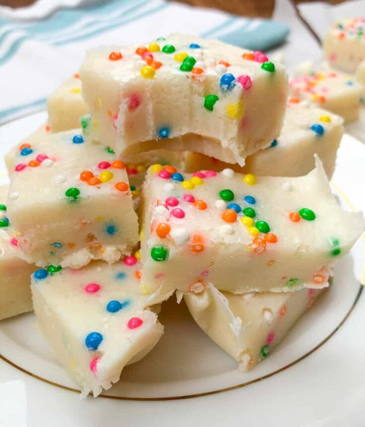 Cake batter fudge cut into pieces and stacked on a white plate