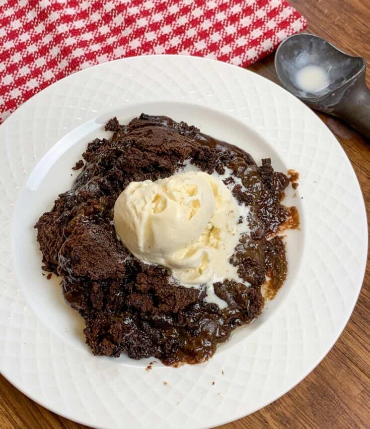 Slow cooker chocolate cake on a plate with vanilla ice cream