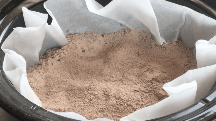 Chocolate pudding mixture on top of chocolate cake in a Crock Pot