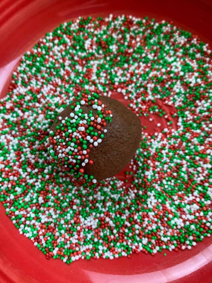 Rolling the chocolate cookies in sprinkles