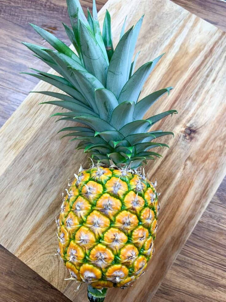 A pineapple sitting on top of a cutting board