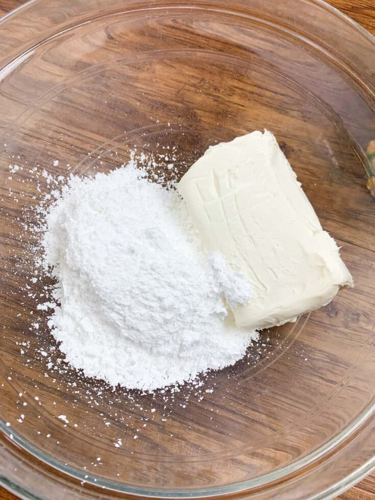 Cream cheese and powdered sugar in a glass bowl