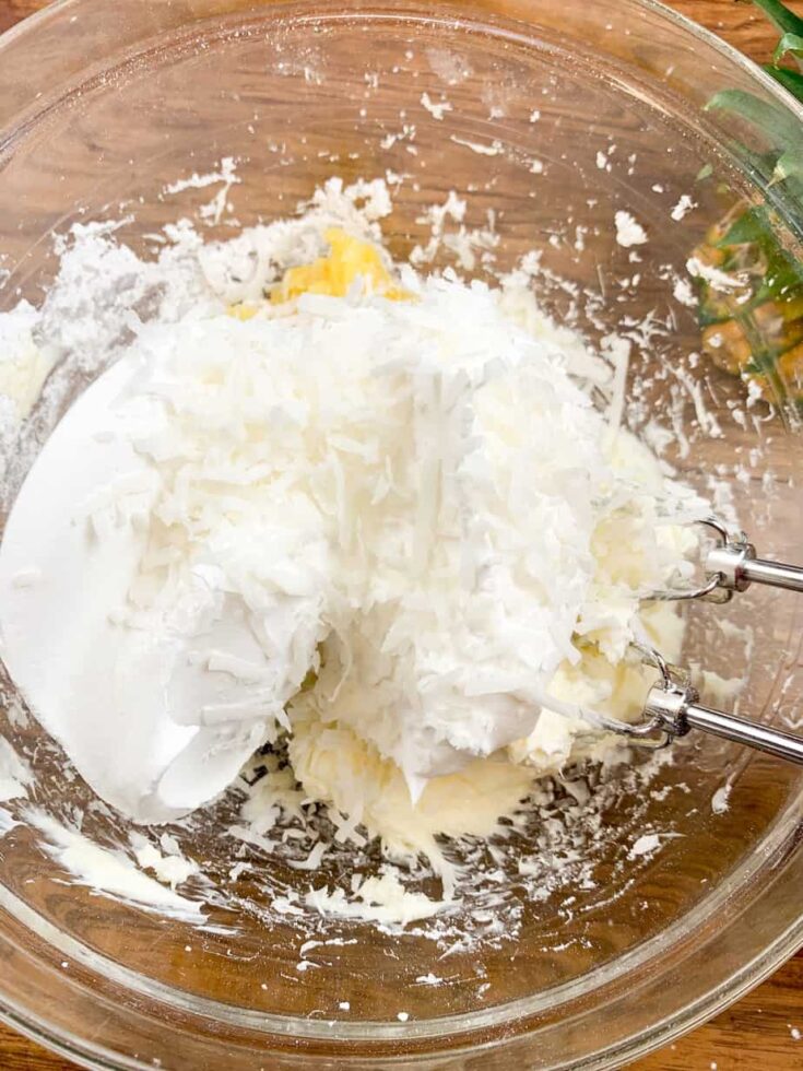 Crushed pineapple, cream cheese, whipped topping, and powdered sugar mixed up in a bowl