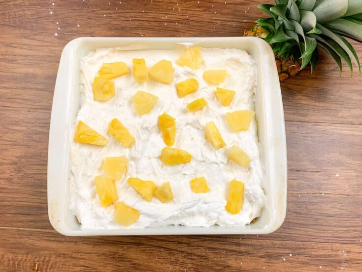 Pineapple lush in a casserole dish with chunks of pineapple on top