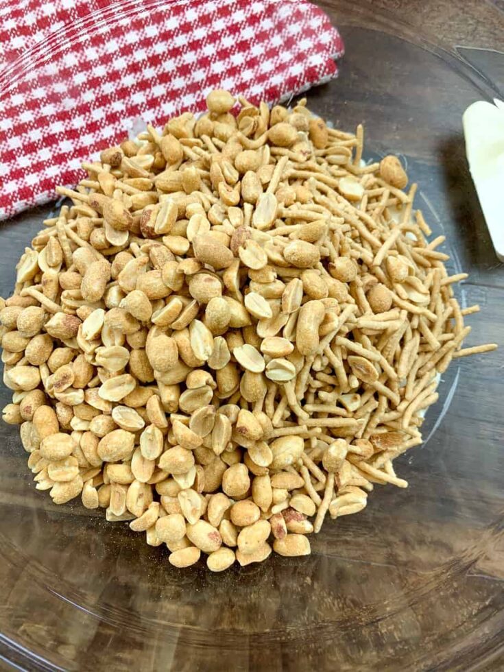 Melted white chocolate, chow mein, and peanuts in a large glass bowl