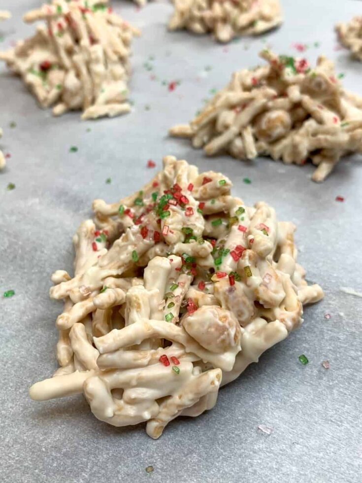 White chocolate haystacks with sprinkles on a cookie sheet