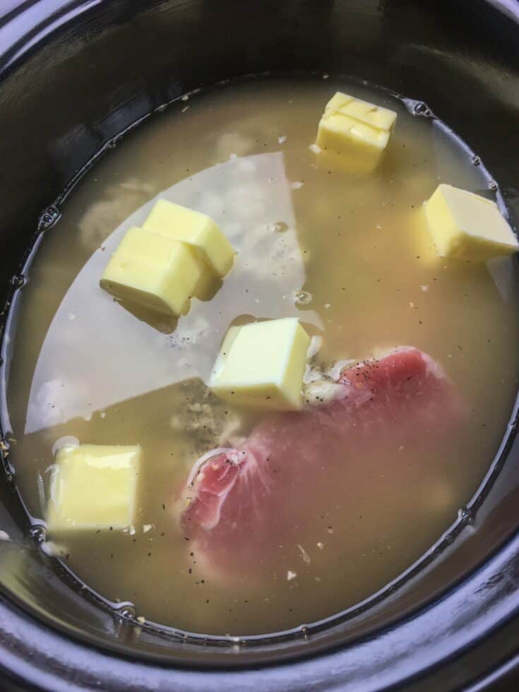 Cubes of butter on top of the pork chops in the slow cooker